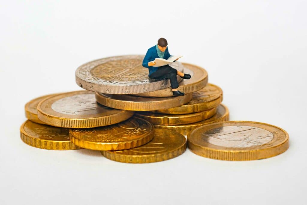 Une personne assise sur un tas d'argent de pièces de monnaies